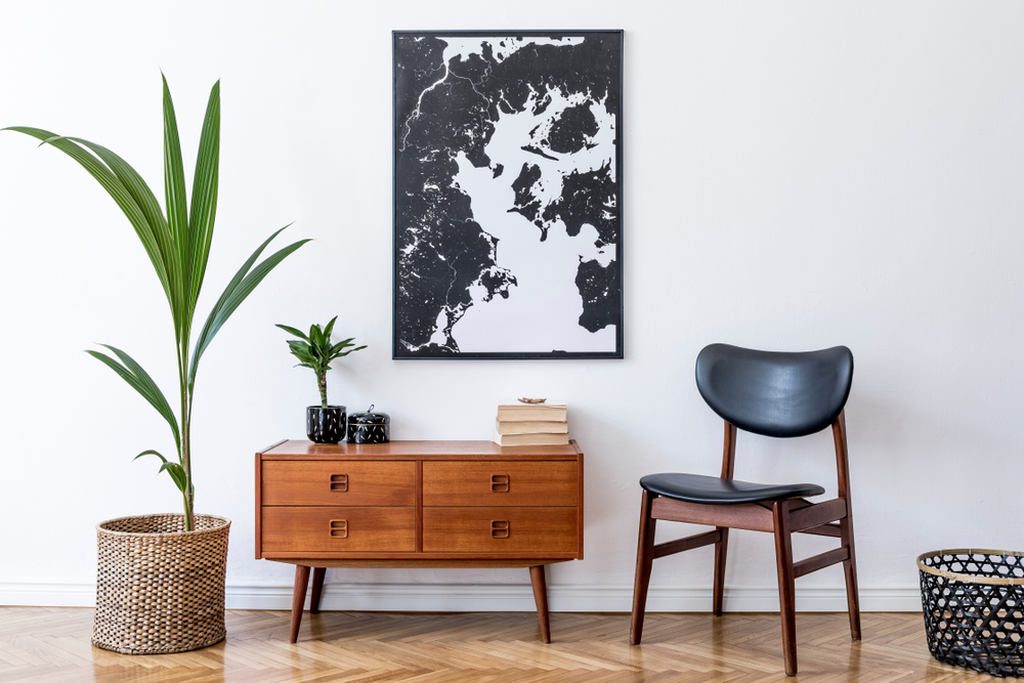 ambiente de uma casa decorada com um quadro, cadeira, escrivaninha e uma planta para valorizar o ambiente com decoração com plantas